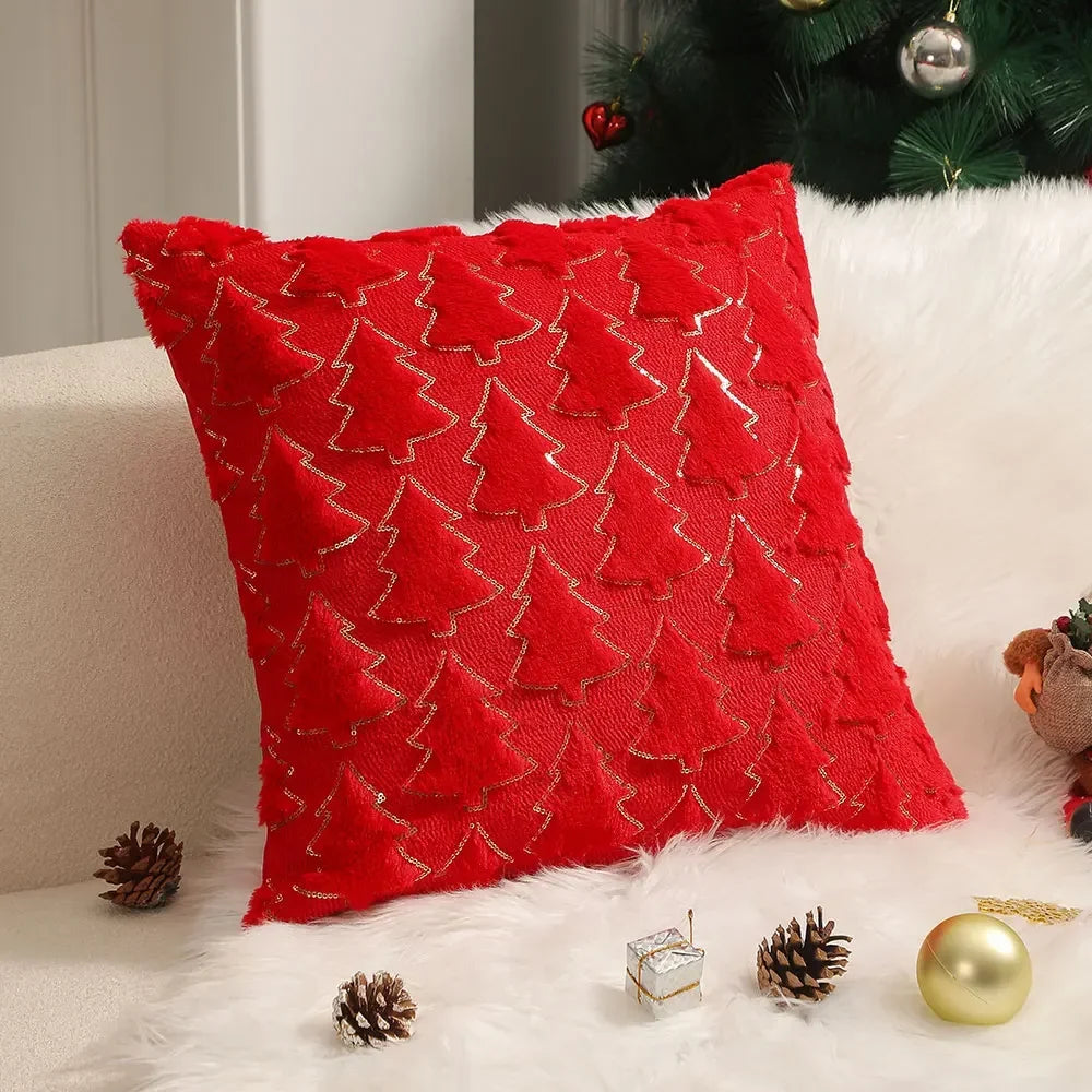 Square red Christmas cushion with raised tree patterns and gold-coloured outlines beside a Christmas tree