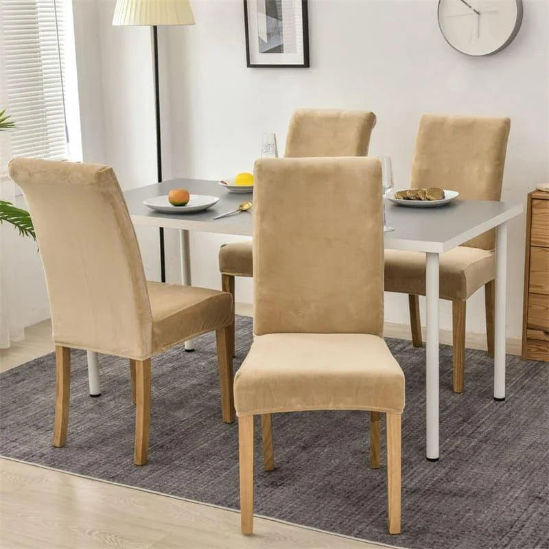 Dining chairs fitted with beige suede covers arranged around a table in a bright dining room.