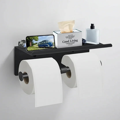 Black double toilet roll holder with a wide shelf holding a phone, tissue box and bottle.