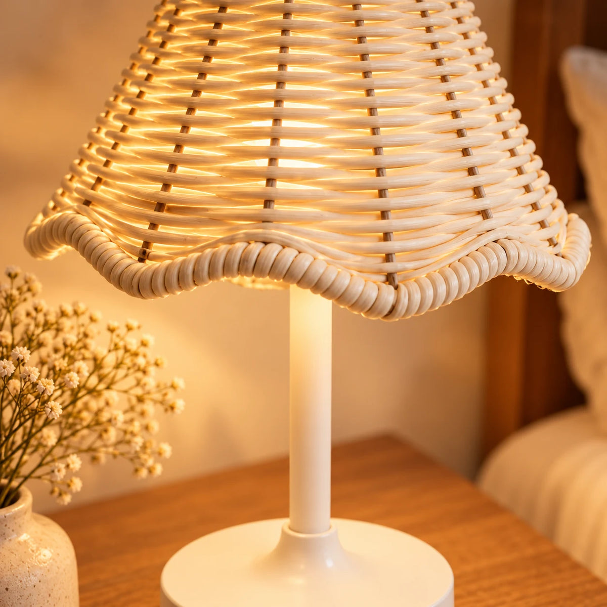Close-up detail of the woven rattan shade and white base of the cordless table lamp