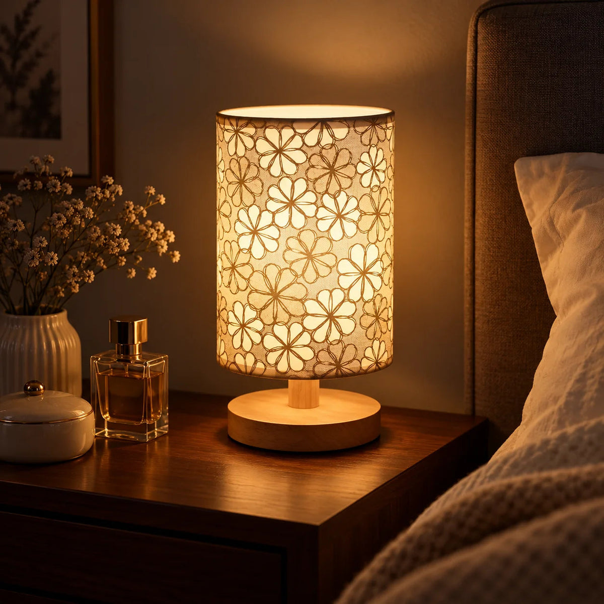Floral fabric shade table lamp with natural wood base styled as warm bedroom lighting
