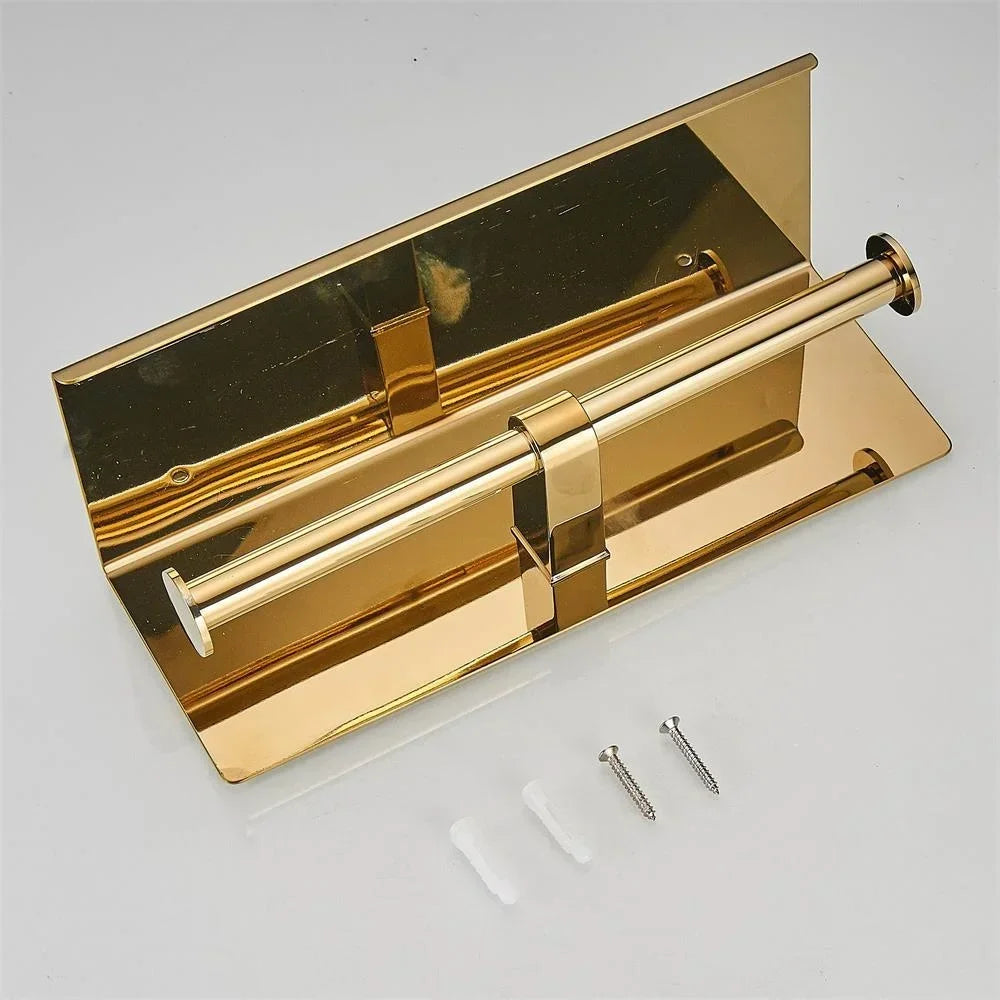 Rear view of a gold-coloured double toilet roll holder beside screws and wall plugs.