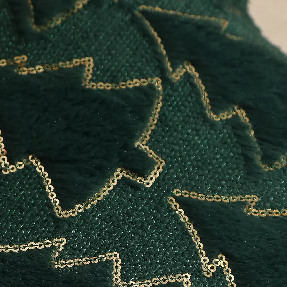 Close-up of raised green Christmas tree shapes and gold-coloured stitched outlines on a cushion cover