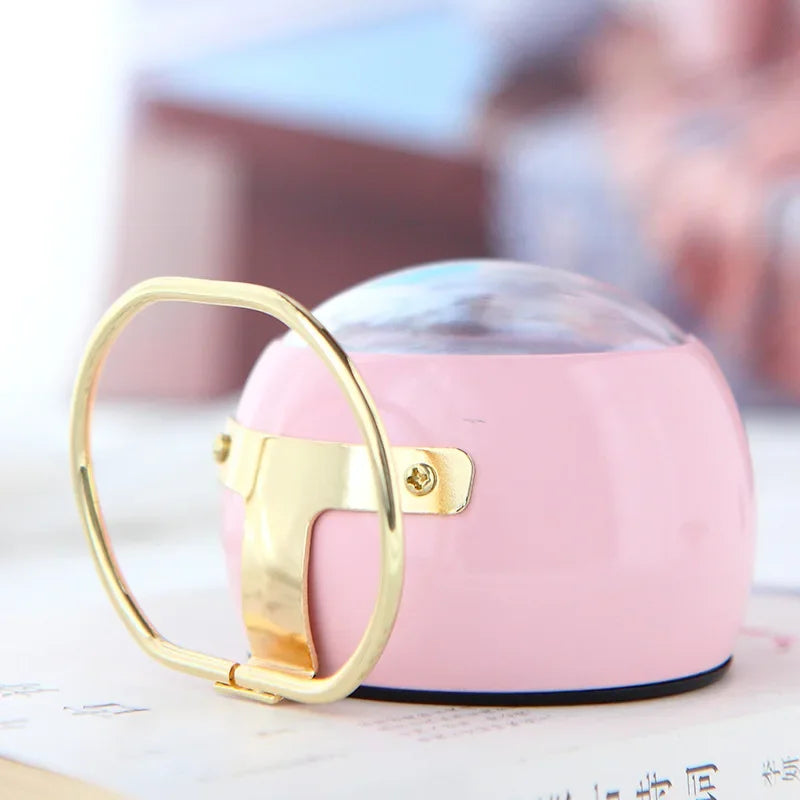 Rear side view of a pink round alarm clock showing its gold-coloured stand and curved case