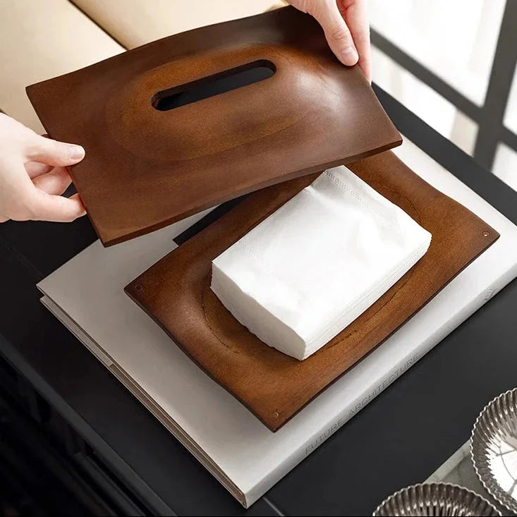 Overhead view of an open walnut wood tissue box cover with its lid lifted above the tissue stack.