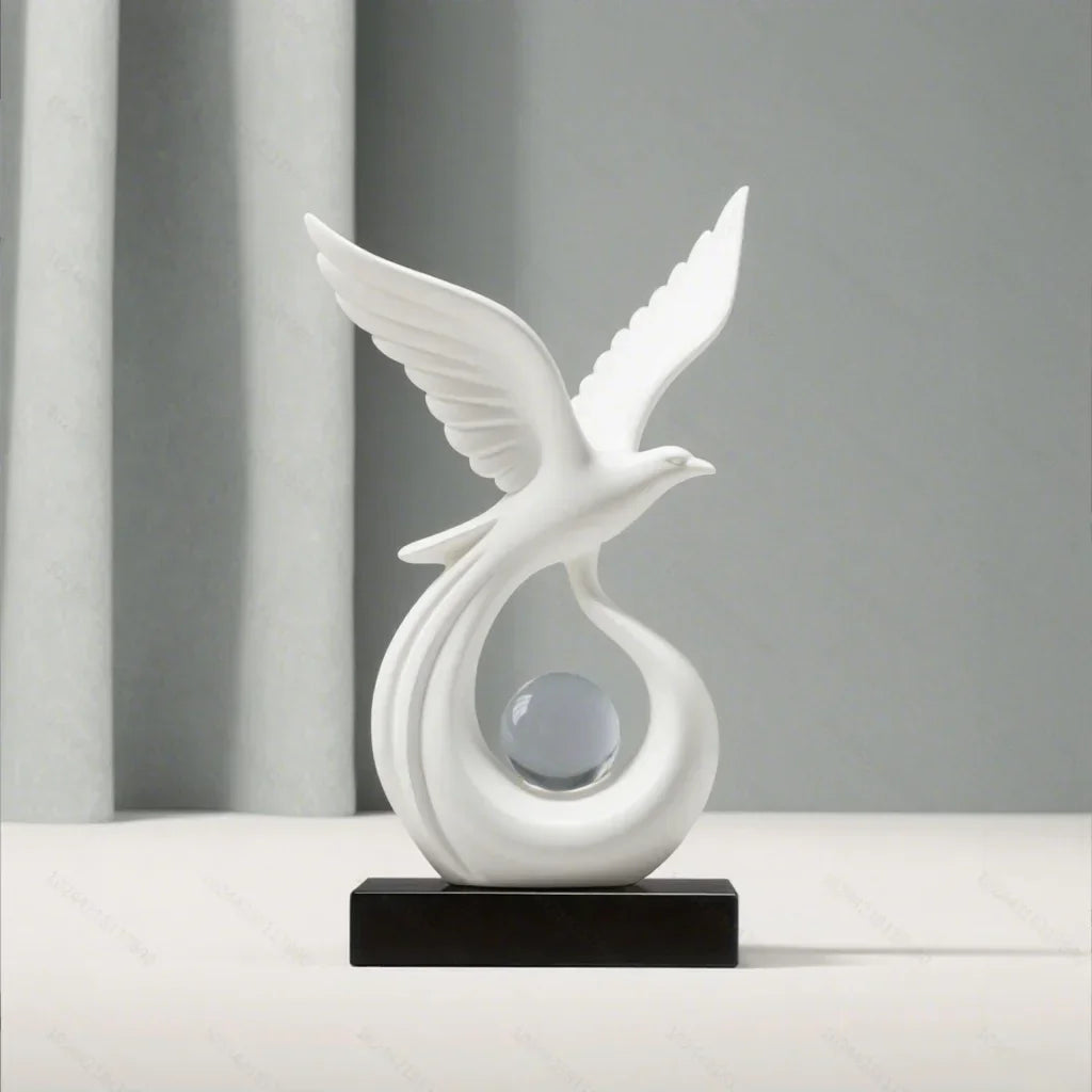 Front view of a white bird sculpture with raised wings and a clear sphere on a black base.