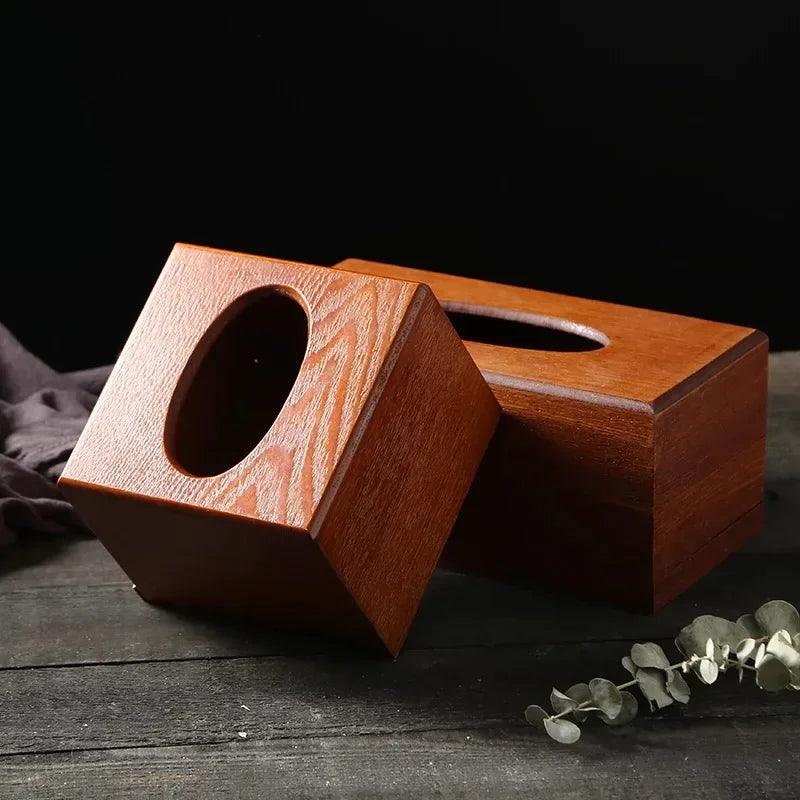 Square and rectangular wooden tissue box covers with oval openings, displayed on a dark surface.